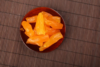 一堆黄色的中国番薯干放在复古的竹台上