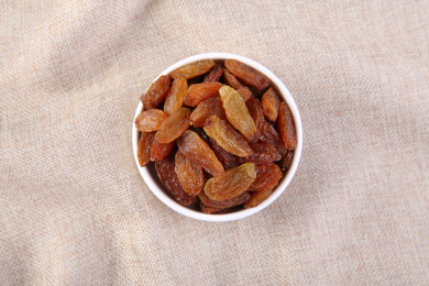 一堆红色的中国红香妃葡萄干放在复古的麻布上