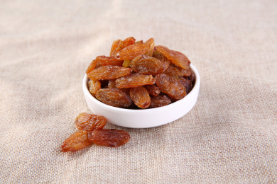 一堆红色的中国红香妃葡萄干放在复古的麻布上