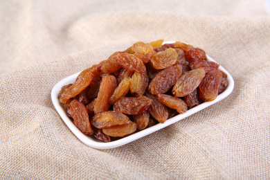 一堆红色的中国红香妃葡萄干放在复古的麻布上