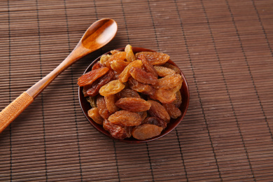 一堆红色的中国红香妃葡萄干放在复古的麻布上