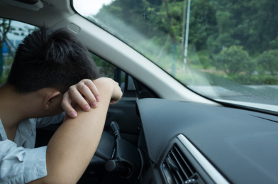 疲惫的中年男性趴在汽车方向盘上面休息