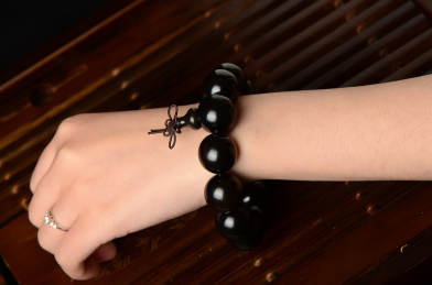 复古风格背景上的黑檀木佛珠手串佩戴图