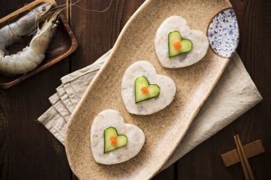 在木纹底古色盘子里装的心形虾滑