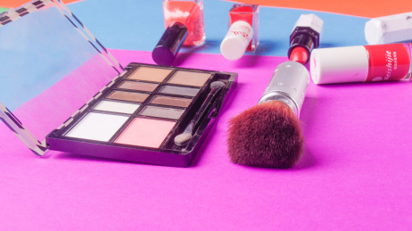 拼色背景上的眼影和刷子