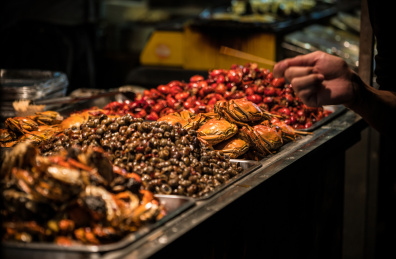 中国武汉户部巷美食街夜市上的炒田螺、大闸蟹、小龙虾等各类美食