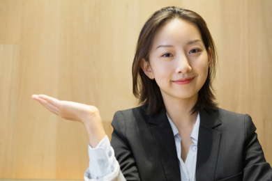 一名亚裔商务女士单手托举手势面带微笑
