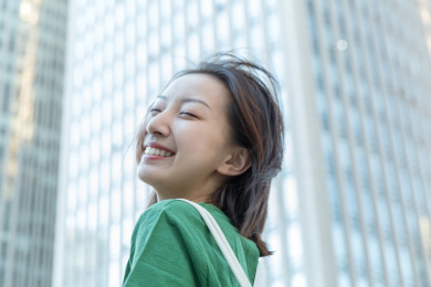 在写字楼前开心大笑的亚裔女人