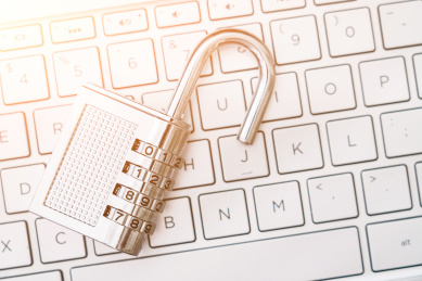 一把打开的锁子放在电脑键盘上