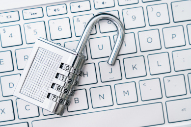 一把打开的锁子放在电脑键盘上