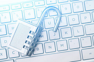 一把打开的锁子放在电脑键盘上