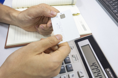 办公桌上的双手拿着一张银行卡