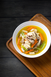 暗色调背景木盘上白色碗里的猪肚