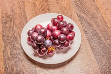 一盘放在褐色木纹背景上的葡萄