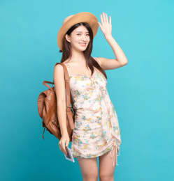  蓝色背景里，手中拿着护照和机票的美丽东方女孩