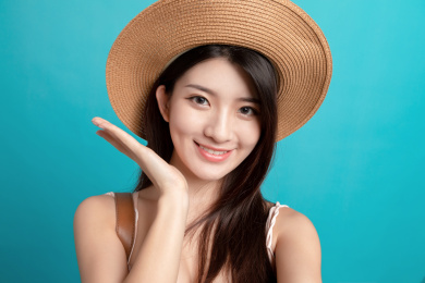 蓝色背景里，对着镜头正在自拍的东方美女