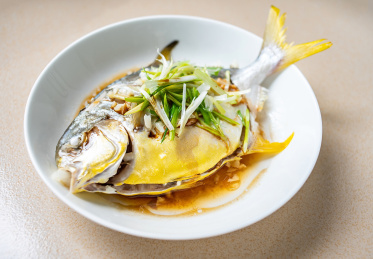 厨房台面上一道烹饪好的中国菜清蒸金鲳鱼