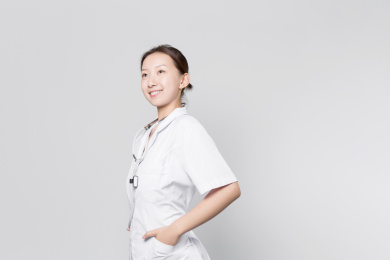 站在灰色背景前自信微笑的女医生目视前方自信微笑