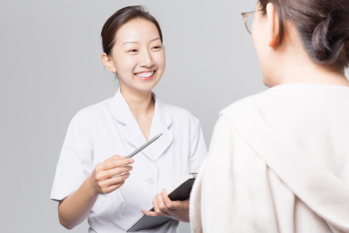 站在浅灰色背景前的女医生和女患者