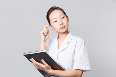 一位身穿白衣的女医生手拿资料正在思考