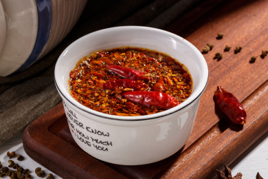 一碗纯手工制作的辣椒油和散落的红辣椒