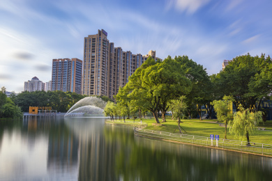 中国广东省中山市岐江公园宁静的湖面与城市对比