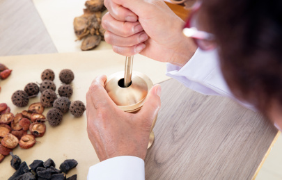 特写拍摄老中医正在使用药臼捣碎中草药