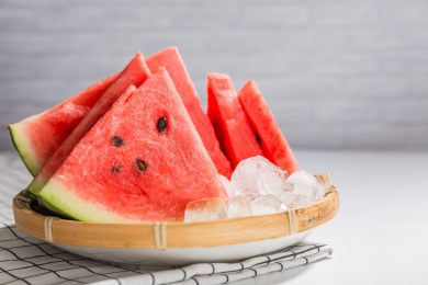 白背景格子餐布上的西瓜和冰块