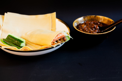 中国传统美食干豆皮卷和肉酱碗黑色背景