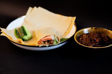 中国传统美食干豆皮卷和肉酱碗黑色背景