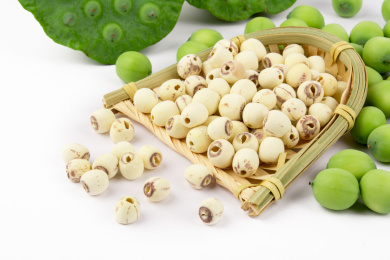 白色背景上放着一些新鲜的莲子、莲蓬和一筐莲子干