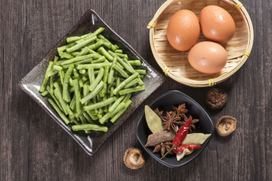 新鲜的豇豆切成段摆放在深色盘子中
