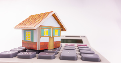 白色背景中的房子和计算器