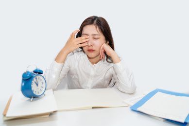 一个中国女白领因为加班熬夜过度劳累而揉着眼睛