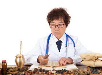 中医药师拿着一块桂皮翻看中药典籍查找资料