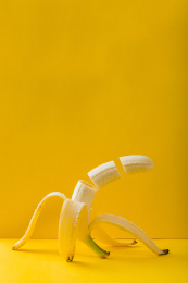 黄色背景上切成三段的香蕉悬浮创意摄影
