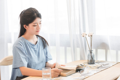  在家里，坐在椅子上正在看书的美丽女孩