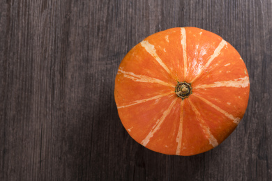 带有黄色花纹的橘红色南瓜摆放在桌面上