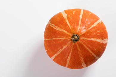 带有黄色花纹的橘红色南瓜摆放在桌面上