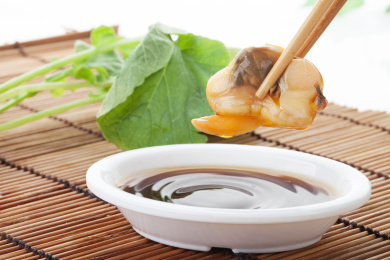 珠帘垫背景上夹在筷子上的花蛤蛤肉