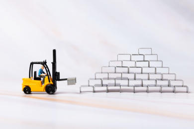 搬运工人开着叉车机械化作业在搬运库房里的订书针