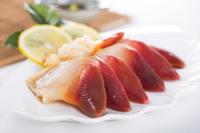 白色背景上装在盘子里的新鲜北极贝肉