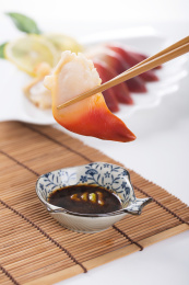 珠帘垫背景上夹在筷子上的新鲜北极贝肉