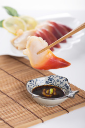 珠帘垫背景上夹在筷子上的新鲜北极贝肉