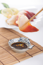 珠帘垫背景上夹在筷子上的新鲜北极贝肉