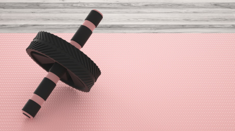 健身题材的木质地板上的塑胶健腹轮和瑜伽垫，3d渲染