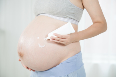 站在窗前手挤护肤品的孕妇