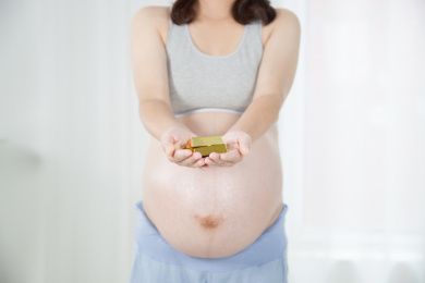 站在窗前手捧金条的孕妇形象