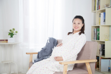 窗前坐在沙发上休息的孕妇