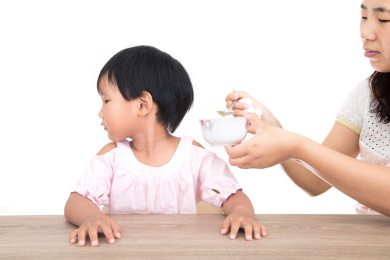 白背景前中国小女孩拒绝妈妈的喂饭